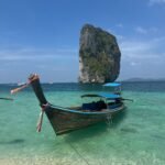 a long boat sitting on top of a sandy beach